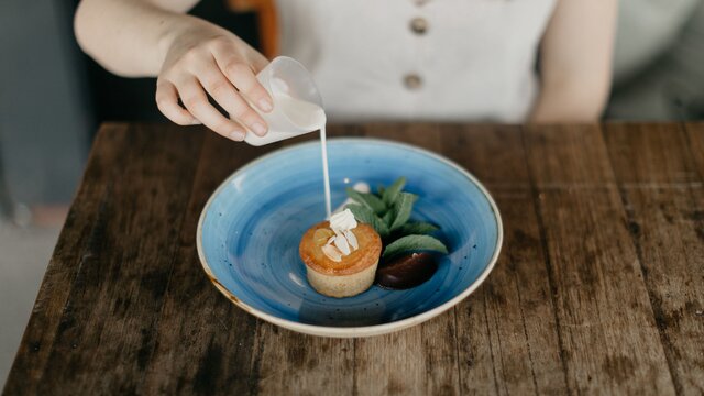 A customer pouring sauce over their meal at Two Before Ten, a cafe.