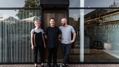 Three staff members standing outside Pilot. Restaurant