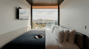 A comfy bed in front of a window looking out across Canberra.