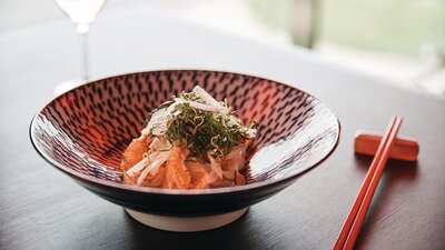 A bowl of food and a glass of wine served up at Chairman and Yip, located inside Hotel Realm in Barton.