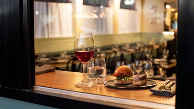 A burger and drink on a window ledge.