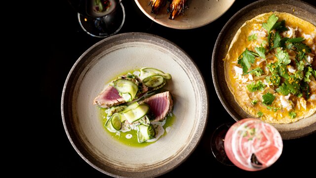 Aerial of some food dishes on a black table at Temporada | © Ashley St George