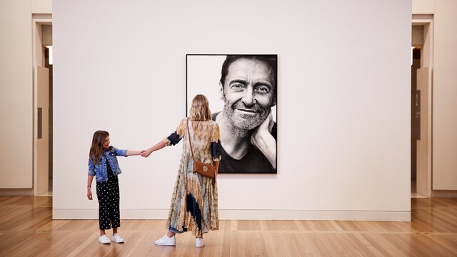 Mum and daughter looking at portrait of Hugh Jackman.