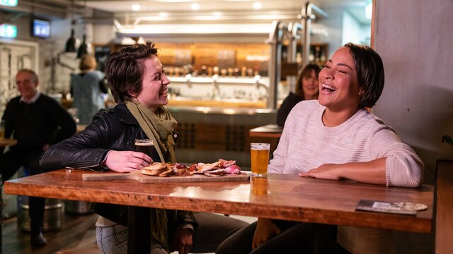Two friends enjoying beer and a charcuterie board at Bentspoke Brewery.