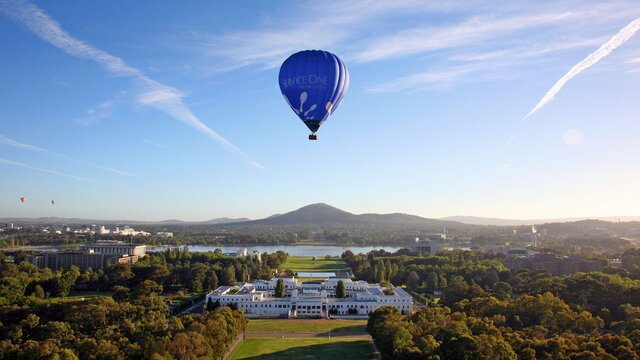 A blue hot air balloon above parliament house.