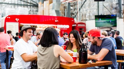 Groups of friends enjoying beer at the Brodburger food truck located in the Capital Brewing Brewery.