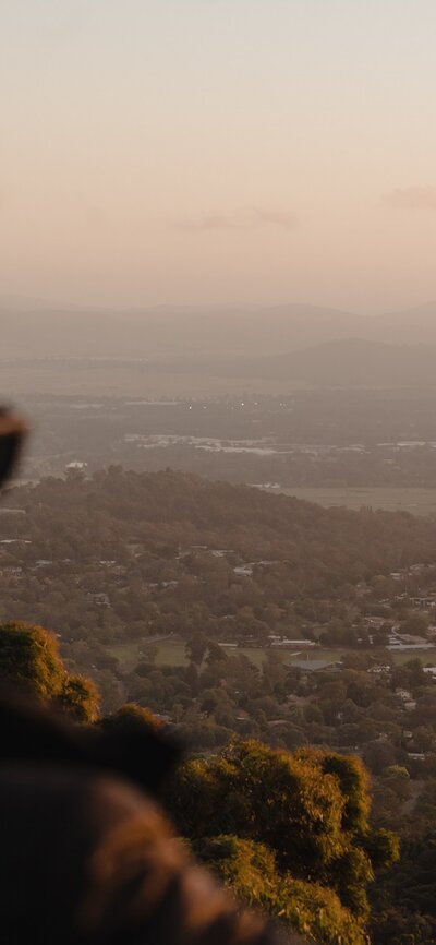 A woman with sunglasses looking out across Canberra.