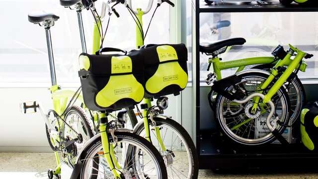 Two yellow bikes with bags.