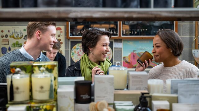 Three mid-twenties people choosing candles.