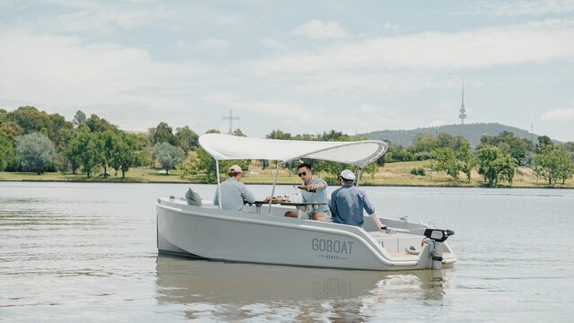 Three friends enjoying a beverage on a boat.