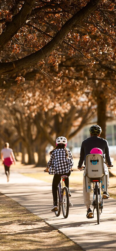 A family enjoying the lakeside and cycling along a path in autumn.