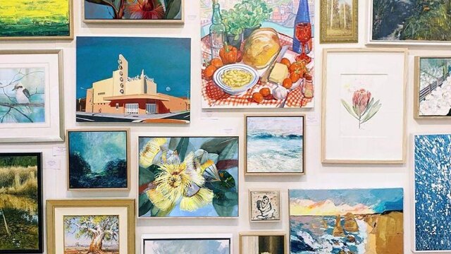 A wall filled with artworks from Aarwun Gallery.