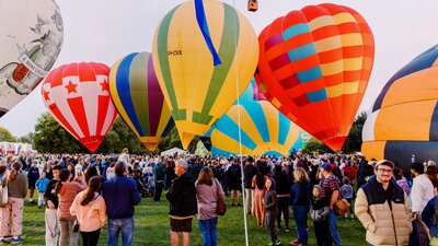 People watching hot air balloons inflate and taking photos