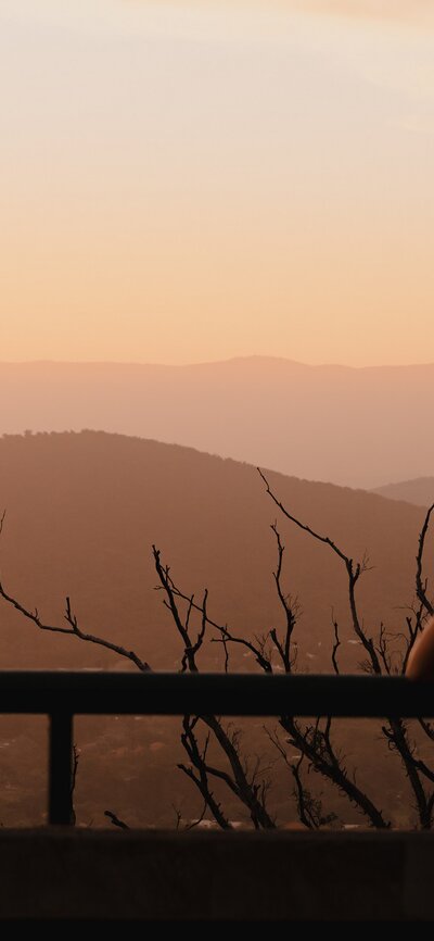 A couple looking out across Canberra as the sun sets.