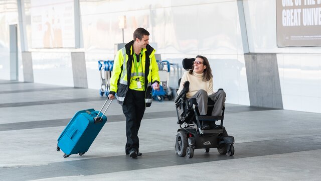 A wheelchair user being supported through their journey around Canberra Airport.