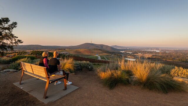 A couple sit and take in a sunset at the National Arboretum.