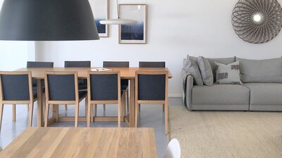 Dining tables, pendant lights and a couch displayed in a showroom