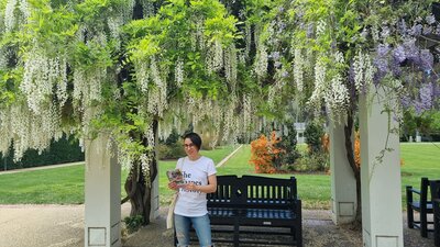 A tour guide under a wisteria tree.