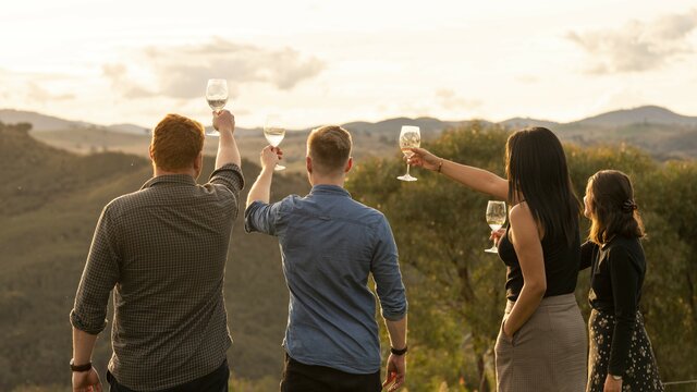 Four friends at a winery with a view of the mountains