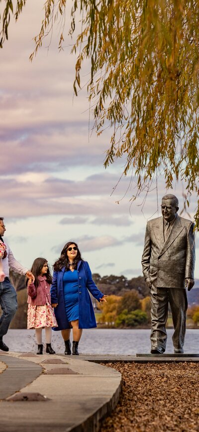 A family is walking alongside picturesque Lake Burley Griffin 