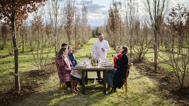 A group of friends sitting down at a table on a truffle farm