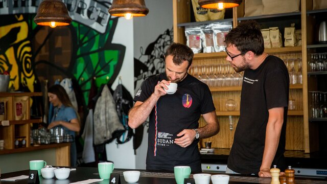 Two men participating in a coffee tasting workshop