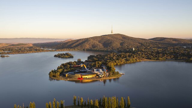 © Adam McGrath Aerial view of the National Museum of Australia in Canberra, on the shores of Lake Burley Griffin, with Black Mountain and Black Mountain Tower in the background. | © Adam McGrath