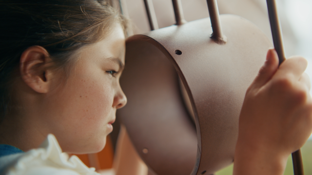A young girl looks to the distance from atop a playground
