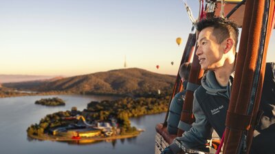A man in a hot air balloon soaring across Canberra national attractions